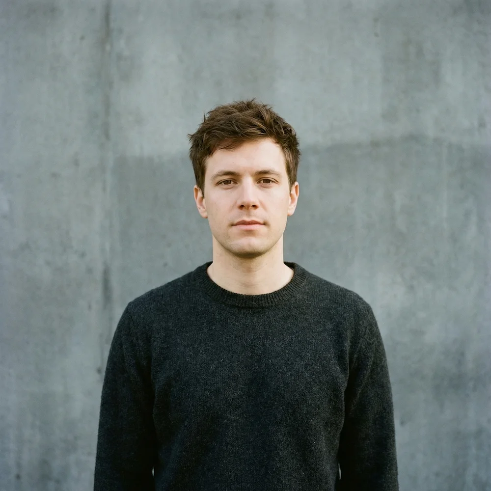 Correct posture and framing, but dark, uneven backdrop
